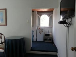 利马艾尔奥利瓦尔住宿加早餐旅馆 的走廊上设有带冰箱和窗户的房间