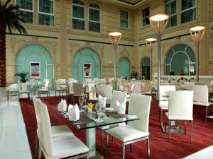 迪拜Villa Rotana的大楼内一家带白色椅子和桌子的餐厅