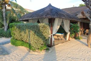 邦劳丽娜海滩度假村的海滩上带草屋顶的凉亭