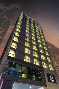 首尔江南欧克劳德酒店的一座高大的建筑,晚上有很多窗户