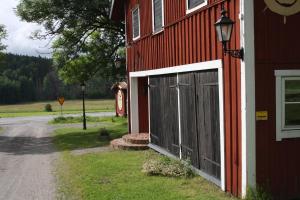EnhörnaLadugårdens Pub & Sal的红色谷仓,旁边有一扇门