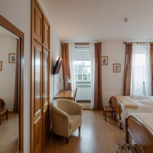 瓜尔达桑托斯酒店的卧室配有床、椅子和窗户。