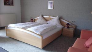 纳瑟尔文勒Landhaus Krinnenspitze的一间卧室配有带白色枕头的木床
