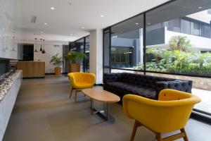 基多Suites Metropoli Bristol Parc的客厅配有黄色椅子和沙发