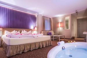 拉迪斯Alpen-Herz Romantik & Spa - Adults Only的酒店客房设有两张床和浴缸。
