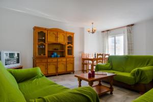科尼尔-德拉弗龙特拉Apartamentos Carril de la Fuente的客厅配有两张绿色沙发和一张桌子