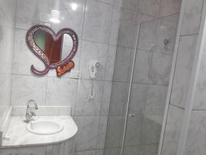 圣保罗Motel Sedução的带淋浴、水槽和心镜的浴室