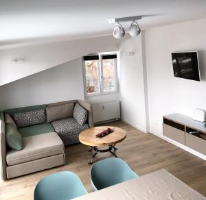 迪森蒂斯库卡格纳公寓的客厅配有沙发和桌子