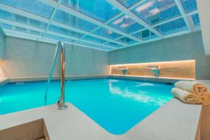 巴塞罗那佩雷四世萨勒酒店的大楼内的一个蓝色海水游泳池