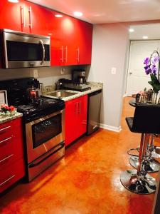 华盛顿圣卡日德尔一室公寓的厨房配有红色橱柜和黑炉