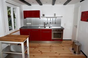 温德克Ferienhaus "Einfach Schön"的一间带红色橱柜和水槽的厨房