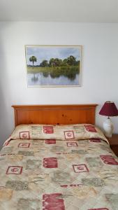 奥里利亚枫树汽车旅馆的卧室内的一张床铺,墙上挂着一幅画