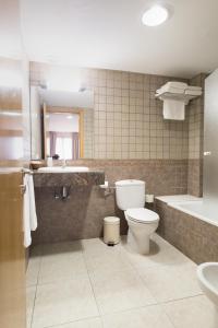 托尔特利亚阿尔塔格罗塔萨旅馆的浴室配有卫生间、盥洗盆和浴缸。