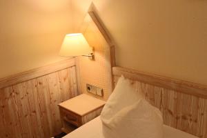 温特贝格桑赫尔酒店的配有带台灯和桌子的床的房间
