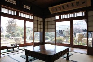 早岛町冈山蔺草旅舍的带桌子的客房位于带窗户的房间内