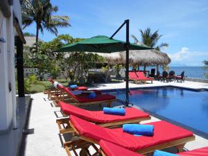 瑟克通银蕨海滩度假酒店的一组椅子和遮阳伞,位于游泳池旁