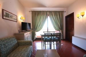 圣托斯特凡诺港Mercure Argentario Hotel Filippo II的客厅配有沙发和桌椅