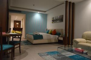 贝鲁特玛尔卡奇亚梦露套房公寓式酒店的一间卧室配有一张床、一张桌子和一张沙发