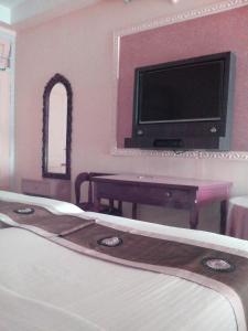 古瓦哈提缅甸玛哈拉克丝米因杜酒店的一间酒店客房,配有一张床和一台电视