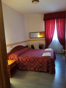 阿尔巴诺拉齐亚莱阿尔缇耶利别墅酒店的酒店客房,配有床和红色窗帘