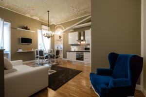 都灵都灵公寓的客厅配有白色沙发和蓝色椅子