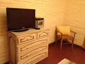 伊瓜苏港巴莎诺瓦套房酒店的梳妆台上带椅子的电视机