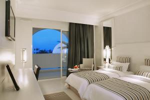 米多恩Djerba Plaza Thalasso & Spa的酒店客房设有两张床和窗户。