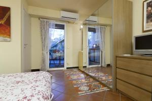 奥尔塔圣朱利奥卡梅拉多切诺特旅馆的一间卧室配有一张床、一台电视和一面镜子