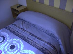 伊伦格玛旅馆的客房内的一张带紫色棉被的床