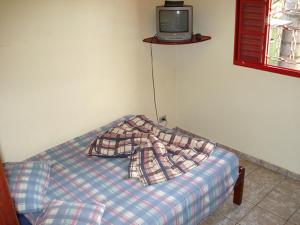 波苏斯-迪卡尔达斯普莱亚索尔旅馆的墙上配有电视的房间里一张床位