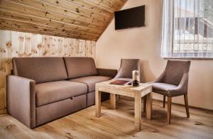 毛特恩多夫schaus Lüftenegger - Apart-Zirbenpension的客厅配有沙发、两把椅子和一张桌子