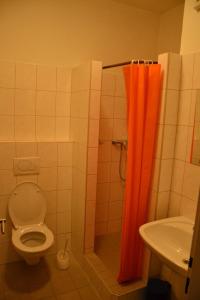 Tvarožná洛恒卡奥斯特利兹汽车旅馆的浴室设有卫生间和橙色淋浴帘