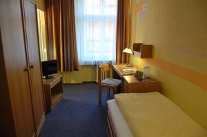 柏林普克勒伽弗酒店的配有一张床和一张书桌的酒店客房