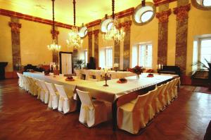 Potštejn波西坦堡酒店的大型用餐室配有长桌和椅子