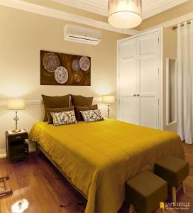 里斯本安全屋公寓的一间卧室配有一张带两把椅子的大型黄色床