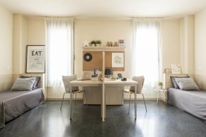 阿尔卡拉德荷那利斯希内尔德洛斯里奥斯大学公寓旅舍的客房设有书桌、两张床和一张桌子。