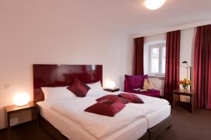 多瑙河畔诺伊堡贝尔格保儿酒店的一间卧室配有一张带红色窗帘的大床