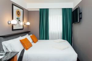 瓦伦西亚马尔科姆和巴瑞特酒店的卧室配有白色的床和绿色窗帘