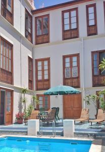 拉奥罗塔瓦阿尔罕布拉酒店的一个带游泳池、椅子和遮阳伞的酒店