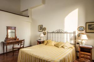 圣吉米纳诺卡斯特罗迪弗利南诺酒店的卧室配有1张床、1张桌子和1把椅子