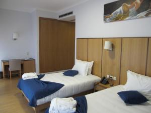 圣佩德罗温泉Hotel Solar da Capela的酒店客房带两张床和电话