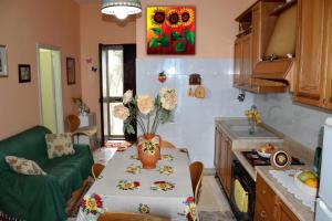 格拉内利Villino Fascinoso by Holiday World的厨房配有一张桌子,上面放着花瓶