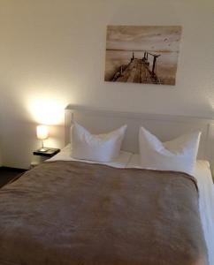 多鲁姆纽菲尔德de Rob Plat的一张带白色枕头的床和一张墙上的照片
