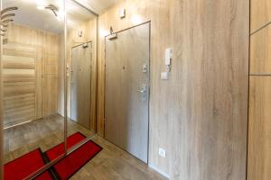 卡尔帕奇Apartament Eva的步入式淋浴间,设有玻璃门和红色地毯