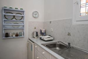 提诺斯普拉西诺奥尼罗公寓的厨房配有水槽和墙上的时钟