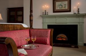 巴尔的摩瑞秋的嫁妆住宿加早餐酒店的两杯葡萄酒,放在带壁炉的红色沙发上