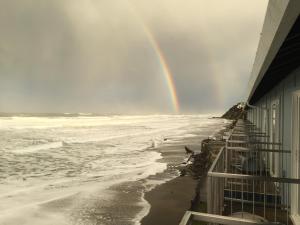 林肯市Sandcastle Beachfront的一座建筑,在海洋上空的彩虹