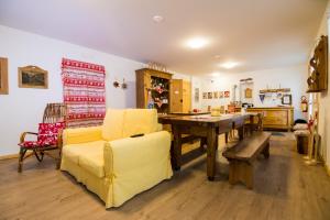 斯基尔帕里奥Olimpic Hostel的客厅配有黄色的沙发和桌子