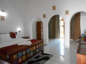 克久拉霍Hotel isabel Palace的一间卧室配有一张床,另一间卧室配有拱门