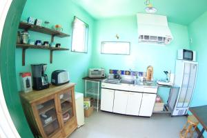 ShishikuiPavilionSurf&Lodge的蓝色的厨房设有水槽和冰箱
